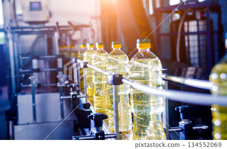 Bottling line of sunflower oil in bottles. Vegetable oil production plant. Bottling line of sunflower oil in bottles. Vegetable oil production plant. 134552069