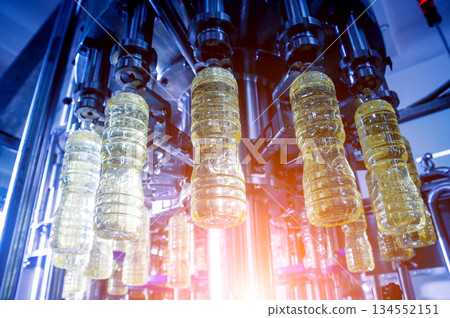 Bottling line of sunflower oil in bottles. Vegetable oil production plant Bottling line of sunflower oil in bottles. Vegetable oil production plant 134552151