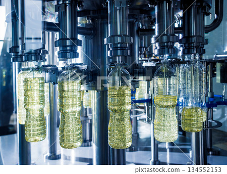 Bottling line of sunflower oil in bottles. Vegetable oil production plant Bottling line of sunflower oil in bottles. Vegetable oil production plant 134552153