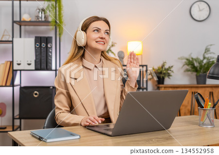 Businesswoman types report with earphones calm music focus rhythm nod focused look productive flow 134552958