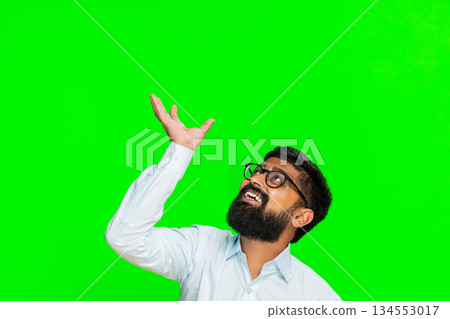 Indian man raising hands looking up reaching above head for promo banner text logo on chroma key Indian man raising hands looking up reaching above head for promo banner text logo on chroma key 134553017