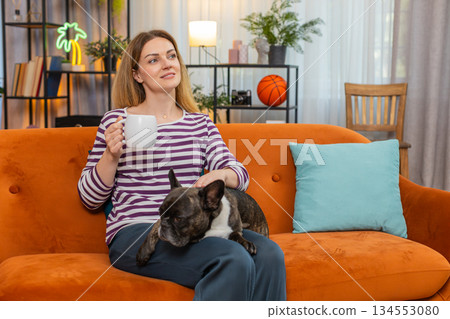 Middle-aged woman with dog enjoys morning tea relaxes calm mood simple break warm drink quiet moment Middle-aged woman with dog enjoys morning tea relaxes calm mood simple break warm drink quiet moment 134553080
