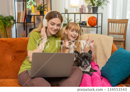 Mother daughter dog wireless headphones lo fi music work on laptop hum sing rhythm with focus family 134553543