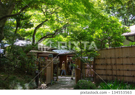 小石川後樂園入口，日式建築掩映在綠樹環繞。遊客們正在參觀這座日式庭園。 134553563
