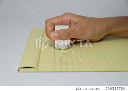 Close-up of a hand erasing notes with an eraser 134553784