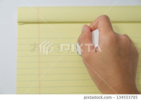 A bird's-eye view of a person erasing notes with an eraser A bird's-eye view of a person erasing notes with an eraser 134553785