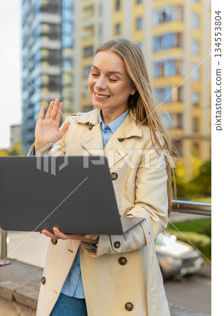Happy mature businesswoman employer on video call using laptop netbook in downtown city street Happy mature businesswoman employer on video call using laptop netbook in downtown city street 134553804