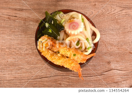 fried crispy shrimp tempura udon orJapanese noodles topping wakame seaweed and pink fish line in Miso soy sauce on bowl fried crispy shrimp tempura udon orJapanese noodles topping wakame seaweed and pink fish line in Miso soy sauce on bowl 134554264