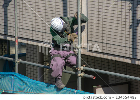 Workers at an apartment building demolition site 134554482