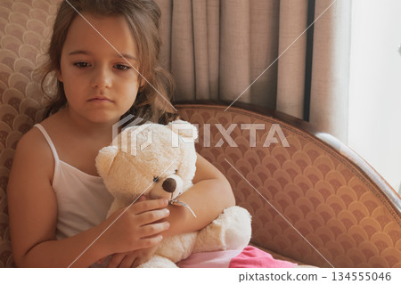Child's comfort: an emotional moment as a girl hugs her toy, seeking solace and refuge Child's comfort: an emotional moment as a girl hugs her toy, seeking solace and refuge 134555046