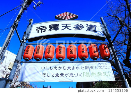 Signs on the Taishakuten approach to Katsushika Shibamata, a tourist attraction, and lanterns shining against the blue sky Signs on the Taishakuten approach to Katsushika Shibamata, a tourist attraction, and lanterns shining against the blue sky 134555396