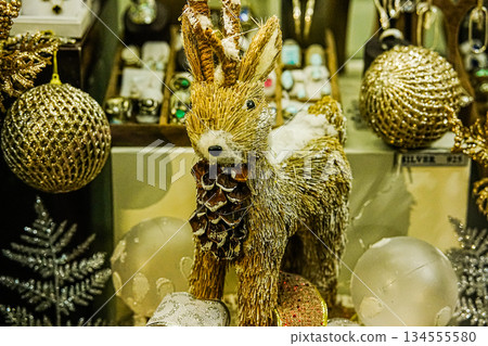 Golden Christmas Ornaments and Deer in Shop Window Display 134555580