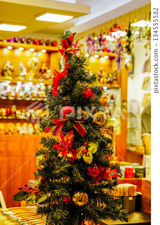 Small Decorated Christmas Tree with Red Bows and Ornaments in Shop Window Small Decorated Christmas Tree with Red Bows and Ornaments in Shop Window 134555582