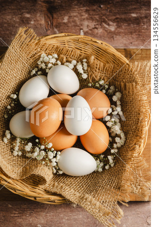 Easter eggs background. White eggs in rustic bowl and gypsophila flowers. Spring holiday 134556629