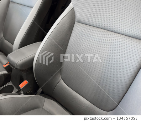 Modern luxury car black leather interior. Part of black leather car seat details with white stitching. Interior of prestige car. Comfortable perforated leather seats. Perforated leather. Modern luxury car black leather interior. Part of black leather car seat details with white stitching. Interior of prestige car. Comfortable perforated leather seats. Perforated leather. 134557055