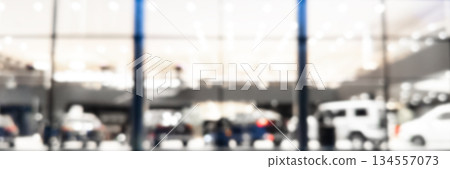 Blurred background with car dealership exterior. Abstract blurred photo of modern building motor showroom. Blur car show room office bokeh lights. Automobile retail shop 134557073