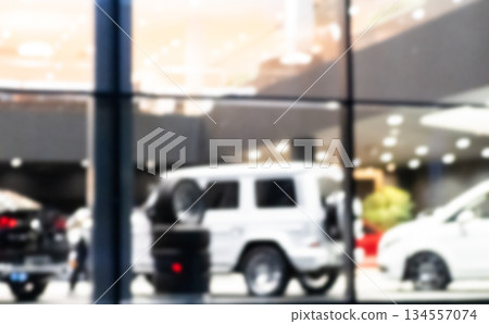 Blurred background with car dealership exterior. Abstract blurred photo of modern building motor showroom. Blur car show room office bokeh lights. Automobile retail shop 134557074