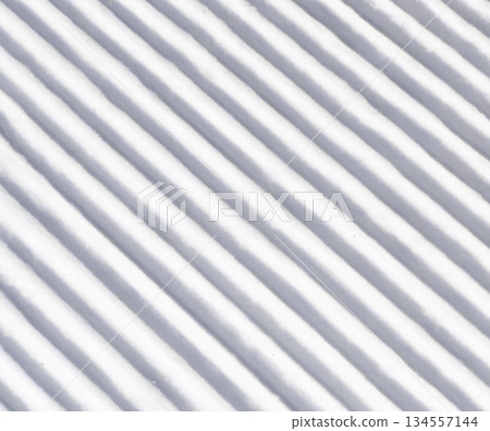 Close up of groomed tracks on a slope in a downhill ski resort. Close-up straight line rows of freshly prepared groomed ski slope 134557144