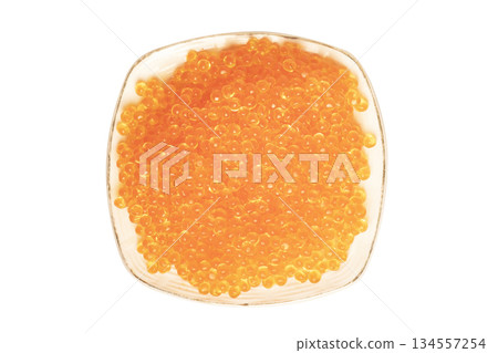 Red caviar in the ceramic plate isolated on a white background. Trout or salmom caviar close up. Macro shot. Top view 134557254