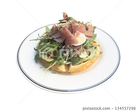 Breakfast time. Waffle with prosciutto, salad and egg for breakfast isolated on white background. Breakfast time. Waffle with prosciutto, salad and egg for breakfast isolated on white background. 134557298