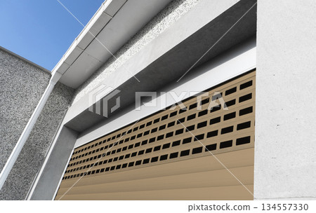 Roller shutter gate. Metal roller garage door as background. Automatic electric roll-up garage gate. Garage with brown rolling gates. Roller shutter gate. Metal roller garage door as background. Automatic electric roll-up garage gate. Garage with brown rolling gates. 134557330