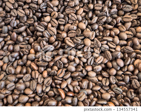Coffee beans texture background. Brown roasted coffee beans. pattern. Closeup shot of coffee beans. Coffee beans texture background. Brown roasted coffee beans. pattern. Closeup shot of coffee beans. 134557341