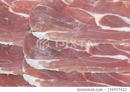 Jamon serrano. A Spanish ham texture background. Traditional spanish jamon sliced. Dry cured meat ham. Hamon iberico Jamon serrano. A Spanish ham texture background. Traditional spanish jamon sliced. Dry cured meat ham. Hamon iberico 134557412