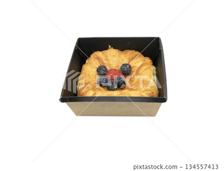 Fresh baked croissant in paper box isolated on white background. Delicious french croissant isolated. Fresh baked croissant in paper box isolated on white background. Delicious french croissant isolated. 134557413