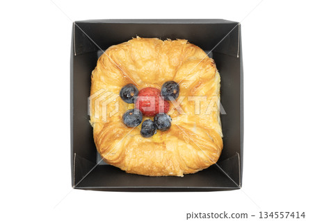 Fresh baked croissant in paper box isolated on white background. Delicious french croissant isolated. Fresh baked croissant in paper box isolated on white background. Delicious french croissant isolated. 134557414