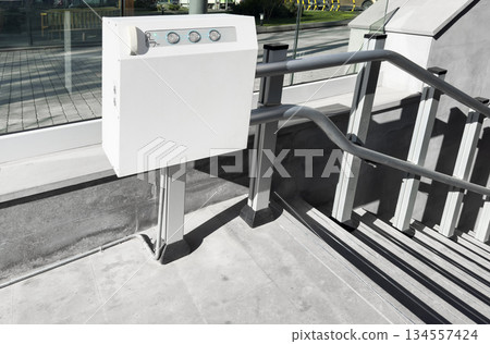 A lift-out lift for the disabled near the entrance. Automatic stair lift on a staircase. Medical stairlift for disabled people 134557424