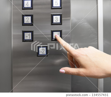 Woman hand pressing push button for elevator. Hand finger press the Elevator button. Woman using Elevator in office or apartment Woman hand pressing push button for elevator. Hand finger press the Elevator button. Woman using Elevator in office or apartment 134557431