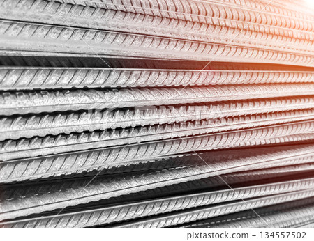 Steel bar or steel reinforcement bar. Construction armature. Reinforcements steel bars in row. The steel rebars. Steel rods bars texture background with sun rays 134557502