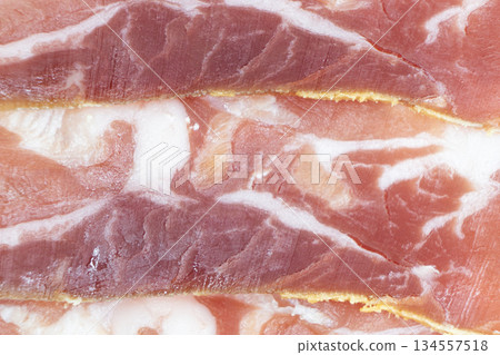 Jamon serrano. A Spanish ham texture background. Traditional spanish jamon sliced. Dry cured meat ham. Hamon iberico. Macro shot Jamon serrano. A Spanish ham texture background. Traditional spanish jamon sliced. Dry cured meat ham. Hamon iberico. Macro shot 134557518