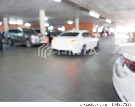 Blurred cars in car parking lot in shopping mall. Bokeh lights background. Abstract blur car parking lot for background. Blurred cars parking 134557521