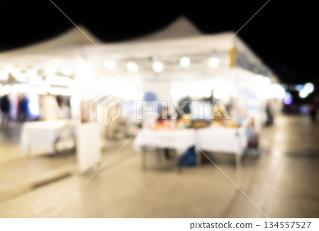 Blurry market fair environment around shopping community and market place at night. Blurred fair background texture with bokeh lights 134557527