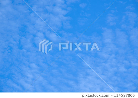 Daytime Moon in a Cloudy Blue Sky 134557806