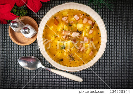 Pea soup with pieces of white sausage, potatoes and small dumplings. 134558544