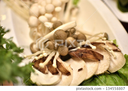 Close-up of assorted mushrooms on a plate, with enoki and shimeji 134558807