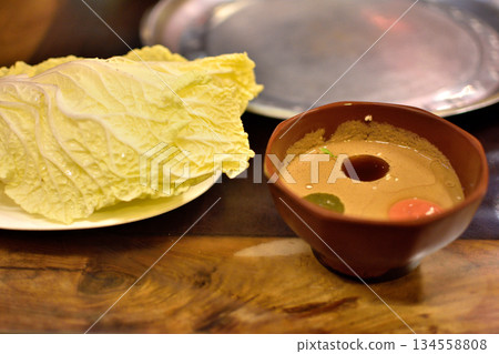 Dipping Sauce and Cabbage Leaves on Wooden Table Dipping Sauce and Cabbage Leaves on Wooden Table 134558808