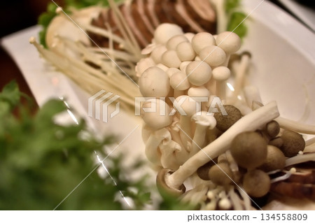 Close-up of assorted mushrooms on a plate, with enoki and shimeji Close-up of assorted mushrooms on a plate, with enoki and shimeji 134558809