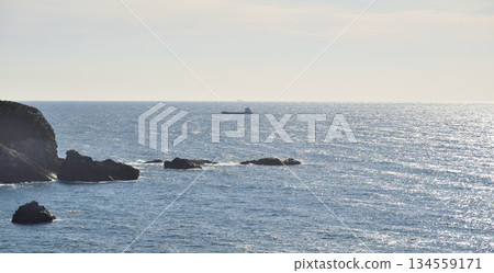 Distant Cargo Ship on Calm Ocean Distant Cargo Ship on Calm Ocean 134559171