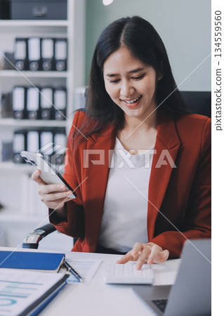 Asian business woman working on a laptop in a professional office 134559560