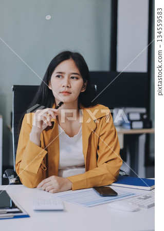Business woman using calculator for do math finance on wooden desk in office and business working background, tax, accounting, statistics and analytic research concept. 134559583