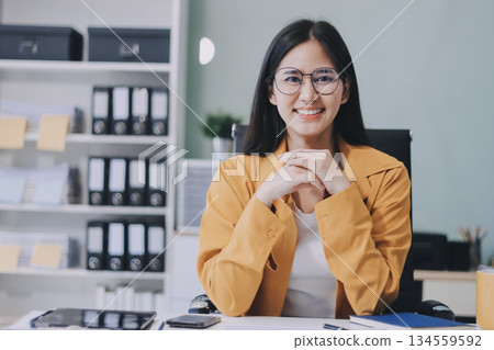 Business woman using calculator for do math finance on wooden desk in office and business working background, tax, accounting, statistics and analytic research concept. Business woman using calculator for do math finance on wooden desk in office and business working background, tax, accounting, statistics and analytic research concept. 134559592