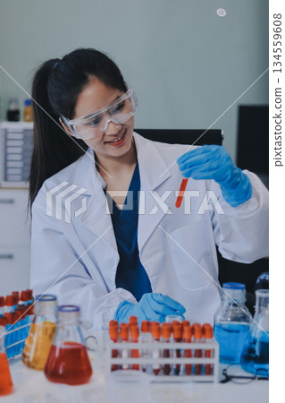 Portrait, science and happy woman on laptop in lab to research chemistry, test or innovation. Microscope, scientist and face of medical doctor in goggles for microbiology, healthcare or pharma study 134559608