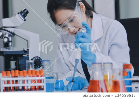Portrait, science and happy woman on laptop in lab to research chemistry, test or innovation. Microscope, scientist and face of medical doctor in goggles for microbiology, healthcare or pharma study 134559613