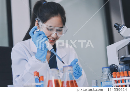 Portrait, science and happy woman on laptop in lab to research chemistry, test or innovation. Microscope, scientist and face of medical doctor in goggles for microbiology, healthcare or pharma study 134559614
