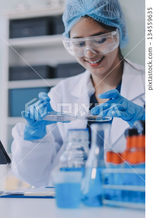 Portrait, science and happy woman on laptop in lab to research chemistry, test or innovation. Microscope, scientist and face of medical doctor in goggles for microbiology, healthcare or pharma study 134559635