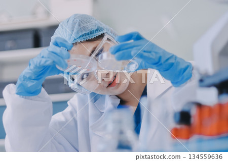 Portrait, science and happy woman on laptop in lab to research chemistry, test or innovation. Microscope, scientist and face of medical doctor in goggles for microbiology, healthcare or pharma study 134559636