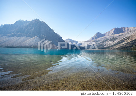 The crystal clear waters of Bow Lake and the tranquil scenery surrounded by mountains The crystal clear waters of Bow Lake and the tranquil scenery surrounded by mountains 134560102